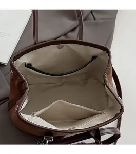Detail view of brown suede bucket bag with magnetic closure and herringbone fabric lining