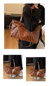 Detail einer braunen Vintage-Leder-Tote mit geflochtenen Griffen und stilvollen Lederquasten