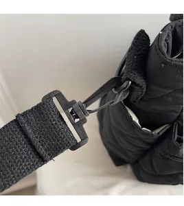 Macro detail of black quilted bag showing durable matte hook and woven canvas strap