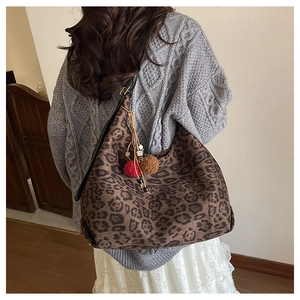Detail of leopard print hobo bag featuring plush texture and colorful pompom tassel