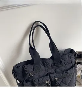 Detailed close-up of a black quilted tote bag with multi-pocket design and nylon straps
