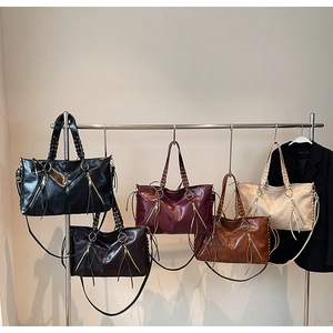 Detailansicht von fünf Retro-Tote-Bags in verschiedenen Farben mit Quasten und Ketten