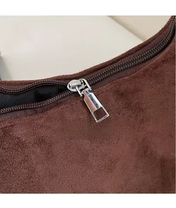 Close-up of smooth silver hardware zipper on brown suede shoulder bag material