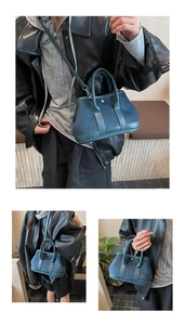 Detail of teal matte leather handbag showing the trapezoid shape and dual handles