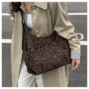 Close-up of vintage leopard print tote bag paired with a khaki trench coat for street style