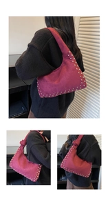 Detail of burgundy matte shoulder bag with silver rivets and unique knotted strap design