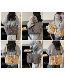Quilted nylon tote bag showing adjustable straps and multiple zip pockets in gray and beige
