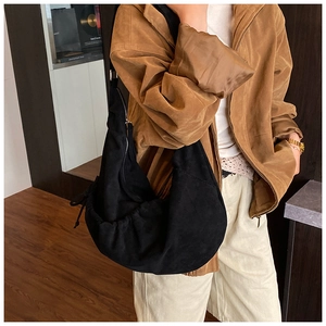 Detail of black pleated hobo bag with adjustable drawstring side and matte finish