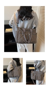 Detail view of large quilted nylon tote with dual front zip pockets and woven rope pulls