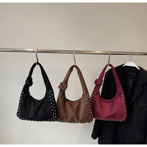 Three suede hobo bags with metal studs and knot straps in black, coffee, and burgundy