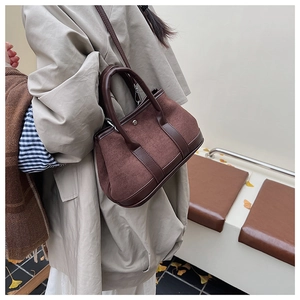 Brown suede patchwork handbag styled with an autumn coat in a scenic outdoor park setting