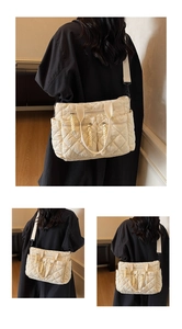 Detail of cream quilted nylon tote with adjustable shoulder strap and multiple zip pockets