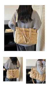 Detail of quilted beige tote bag showing multiple zipper pockets and braided pullers