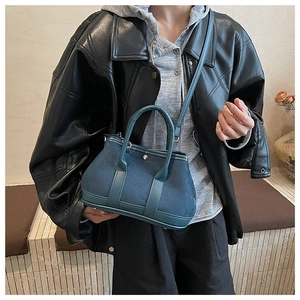 Detail of the blue suede tote bag with leather piping and a metal twist-lock buckle