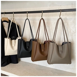 Group display of four stylish tote bags in white, black, brown, and taupe leather texture