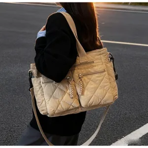 Quilted nylon tote bag with dual front zip pockets and wide shoulder strap in beige