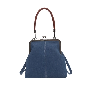 Retro blue denim crossbody bag with metal kiss-lock and brown handle on white background