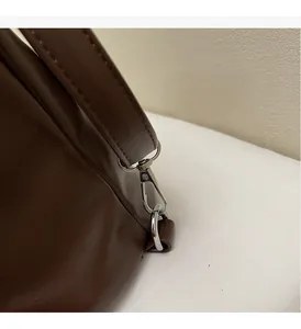 Detail of silver lobster clasp and premium brown leather strap on retro commuter bag