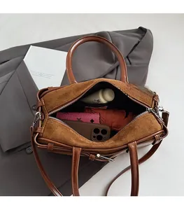 Brown suede Boston bag showing large interior capacity with phone and cosmetics