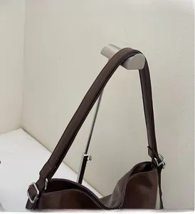 Close-up detail of durable dark brown leather shoulder straps and silver metal hardware
