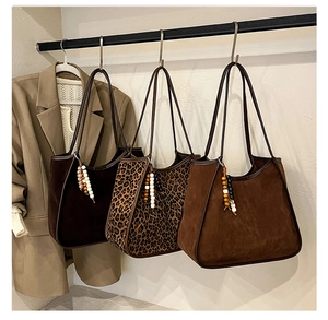 Detail view of large leopard print faux suede tote bags with decorative colorful bead charms