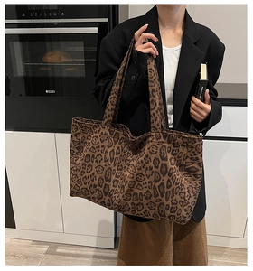 Detail of spacious leopard print tote bag with wide handles shown in a lifestyle setting