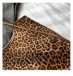 Macro view of leopard print tote bag with brown leather piping and refined stitching