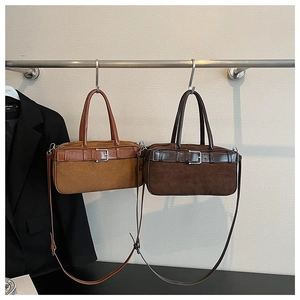 Detail showing two retro suede Boston bags in light and dark brown with leather straps