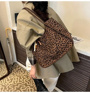 Detailed back view of a leopard print tote bag with brown straps and beaded charm