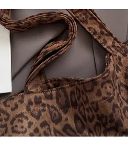 Detail view of reinforced stitching and leopard print texture on a large tote bag