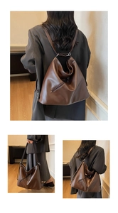 Detail of dark brown vintage leather backpack showing multi-functional strap modes