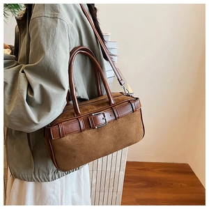 Detail of vintage brown suede patchwork bucket bag with leather handles shown in interior