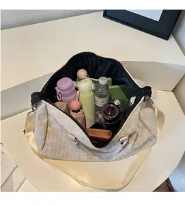 Interior view showing the large storage capacity of the woven cream travel duffel bag