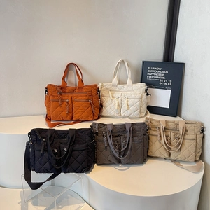Quilted nylon tote bags in five colors with dual front pockets and adjustable straps