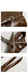 Detail view of dark brown PU leather shoulder bag with silver metal buckles and zippers
