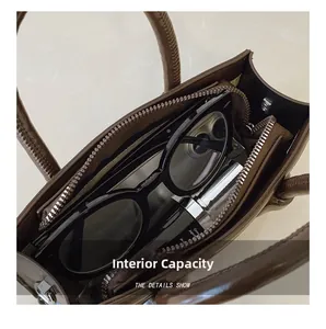 Detail view of the brown leather bag interior showing a zipper compartment and capacity