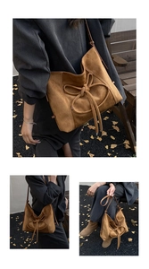 Détail d'un sac cabas en daim caramel avec grand nœud porté dans un décor d'automne