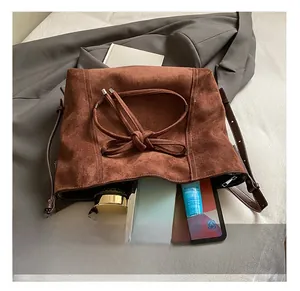 Vue de dessus d'un grand sac bandoulière en daim marron montrant son intérieur spacieux