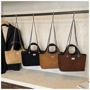 Quilted tote bags in four colors with chain straps and turn-lock on a metal display rack