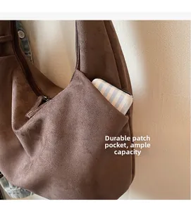 Detalle del bolsillo de parche duradero y cremallera lateral en un gran bolso hobo de gamuza