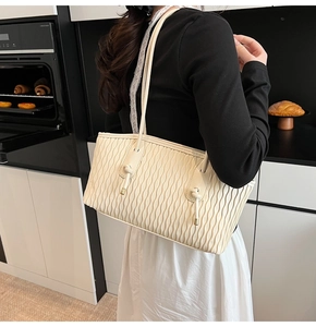 Nahaufnahme der cremeweißen Tragetasche mit 3D-Wellenstruktur und eleganten Knotendetails