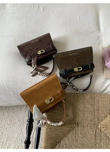 Detalle de bolsos de gamuza con asas de seda y cierres giratorios dorados