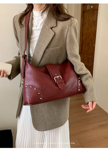 Detail of burgundy tote bag with silver studs and buckle on premium matte leather