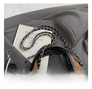 Detail of brown quilted suede tote bag with black chain strap and silver hardware