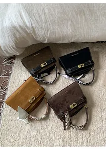 Detalle de cuatro bolsos de ante con asas envueltas en bufandas de seda de colores