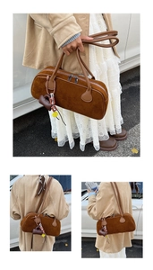 Detail of brown suede cylinder bag with beaded charm and double zipper for women