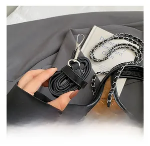 Detail of adjustable black leather strap and silver chain on brown quilted tote bag
