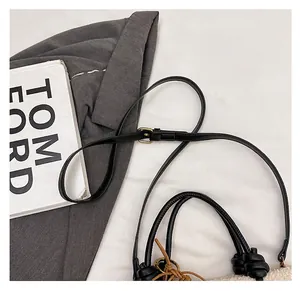 Detail der Winter-Plüschtasche in Creme mit schwarzem Ledergriff und Knotendekoration