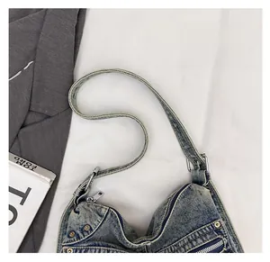 Détail du cabas en denim vintage montrant son tissu bleu délavé et ses rivets argentés