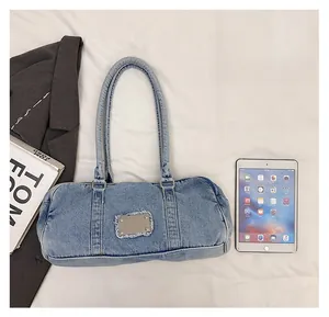Washed denim shoulder bag shown with an iPad to illustrate spacious daily capacity